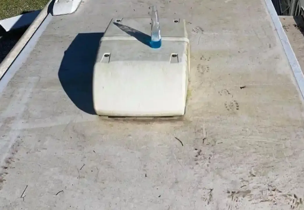 RV roof leak repair in Fort Lauderdale Florida - certified technician applying Dicor lap sealant around AC unit and vent penetrations after hurricane damage